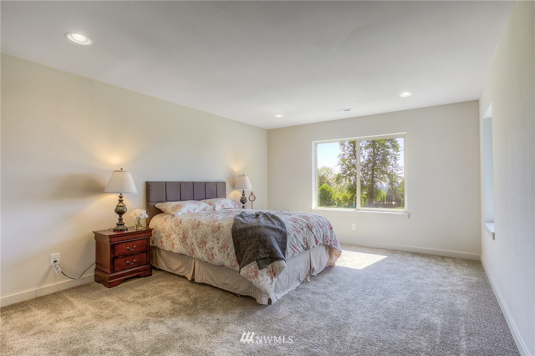 719 Southwest Langston Road Renton, WA 98057 - Photo 14 of 25 a spacious bedroom with a bed and a large window