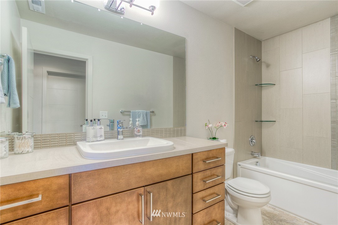 719 Southwest Langston Road Renton, WA 98057 - Photo 21 of 25 a bathroom with a granite countertop sink a toilet and a large mirror