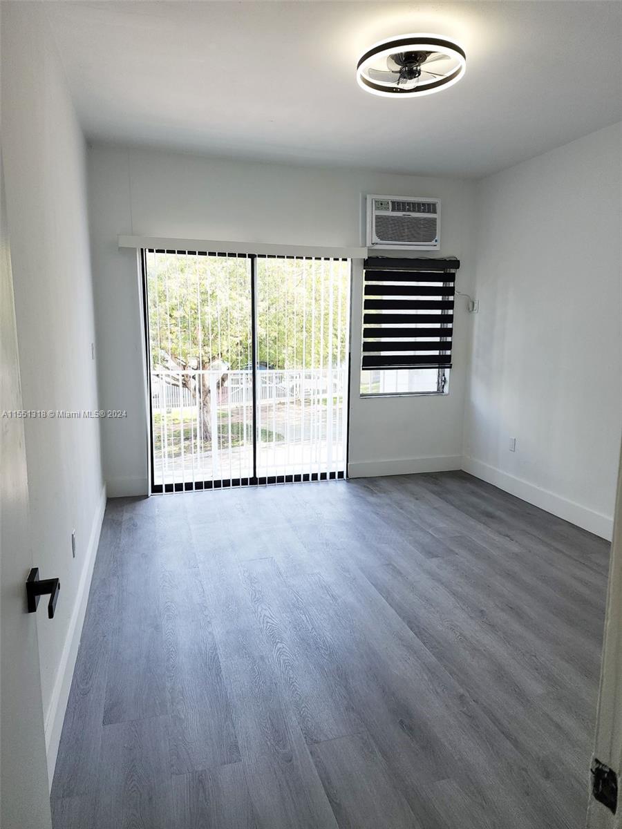 2101 Normandy Drive, Unit 204 Miami Beach, FL 33141 - Photo 13 of 30 an empty room with wooden floor and windows