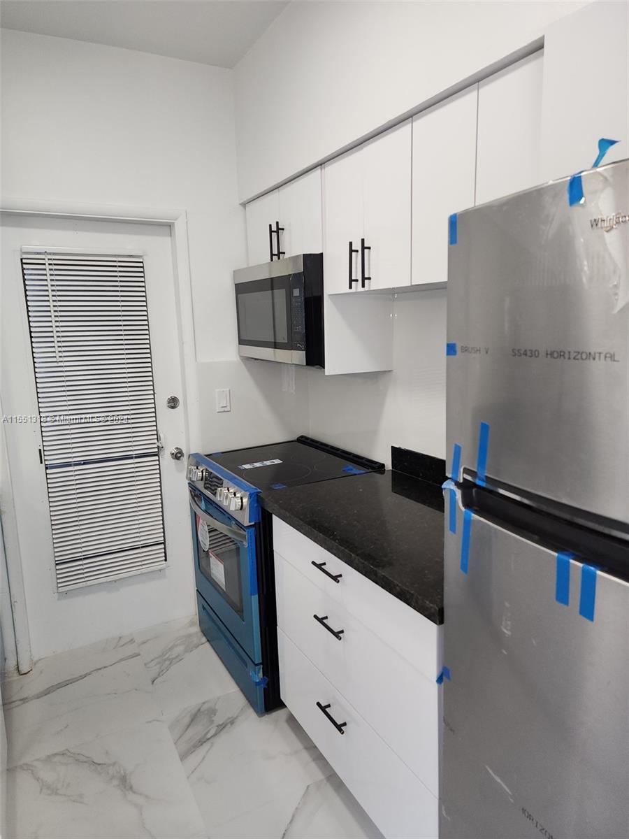 2101 Normandy Drive, Unit 204 Miami Beach, FL 33141 - Photo 16 of 30 a kitchen with stainless steel appliances granite countertop a refrigerator and a stove