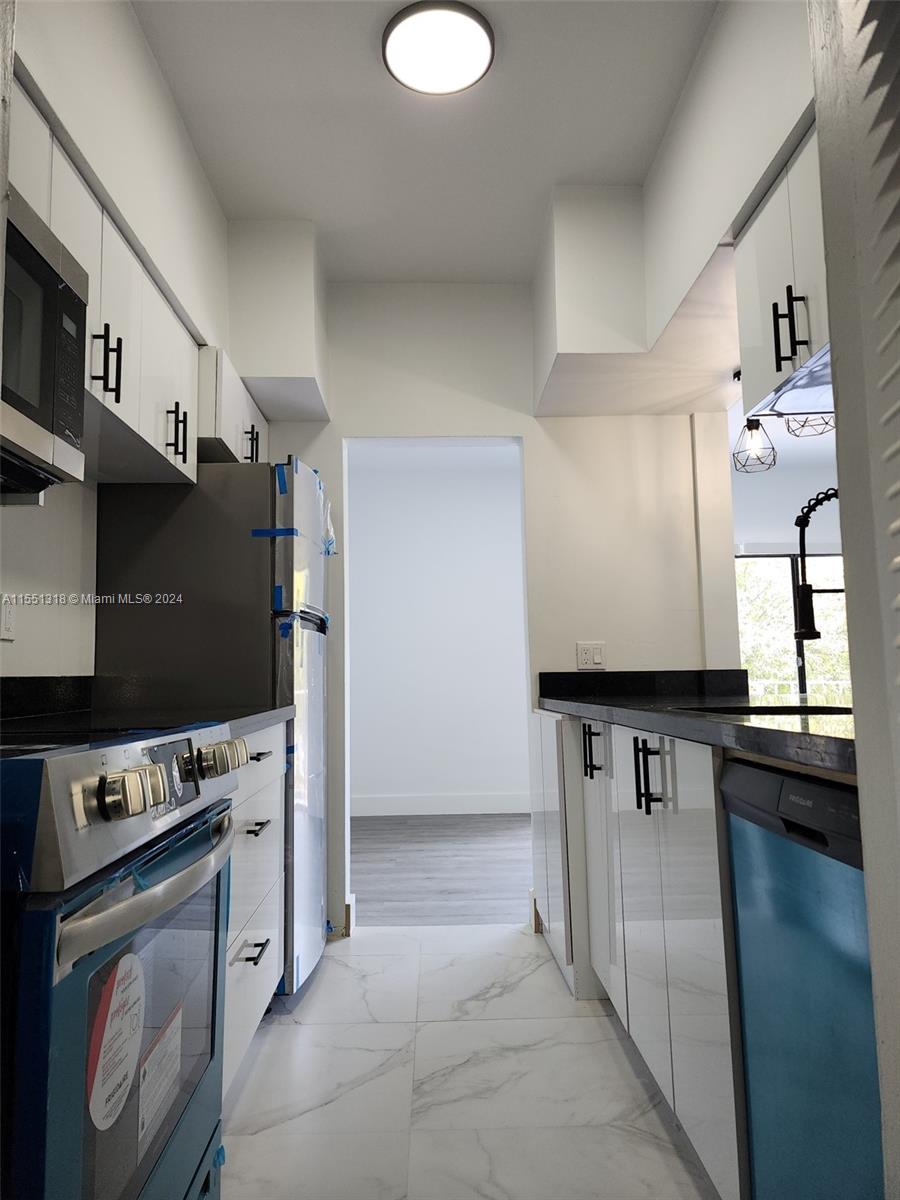 2101 Normandy Drive, Unit 204 Miami Beach, FL 33141 - Photo 19 of 30 a kitchen with stainless steel appliances granite countertop a stove a refrigerator and a sink