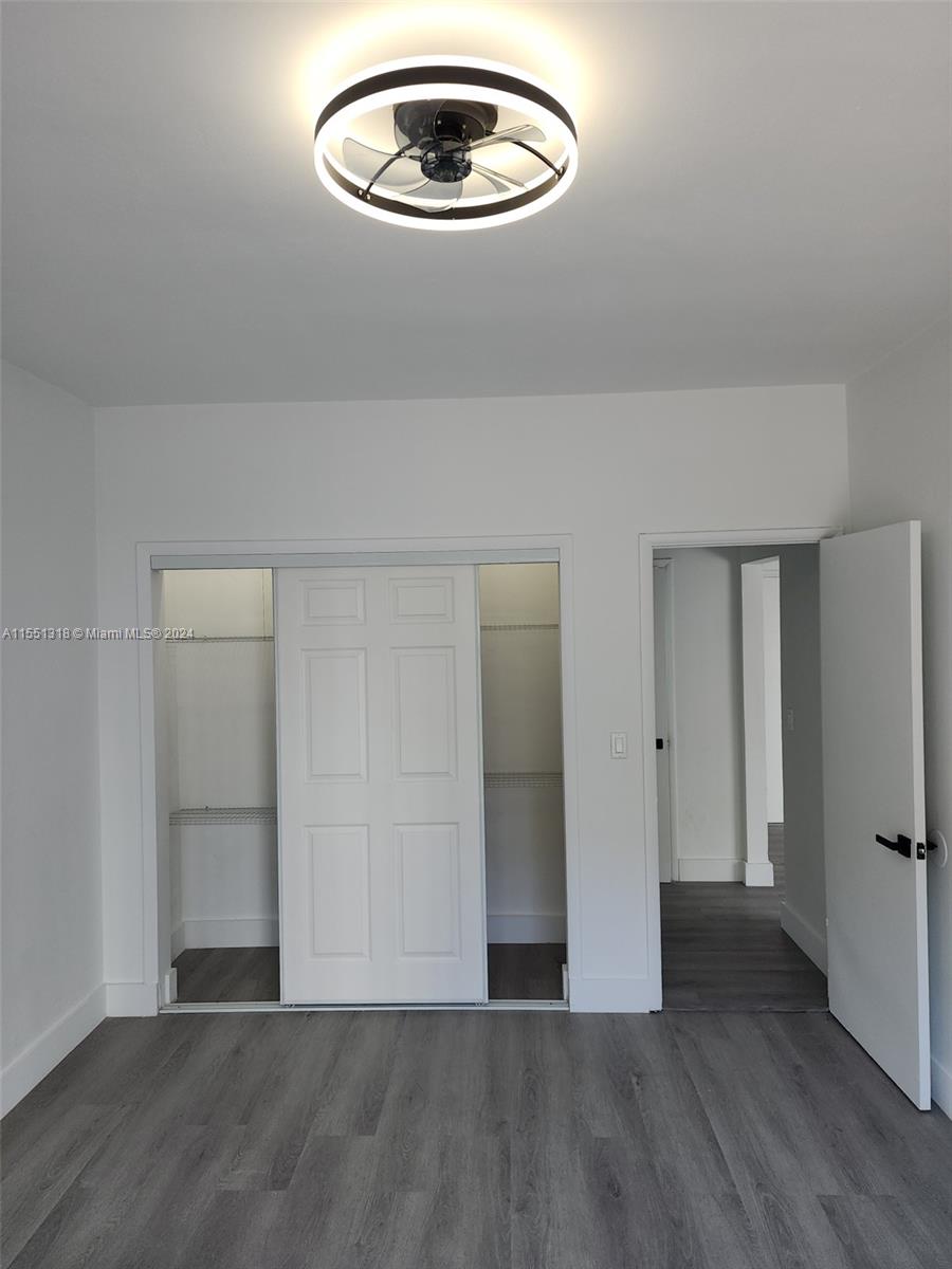 2101 Normandy Drive, Unit 204 Miami Beach, FL 33141 - Photo 24 of 30 an empty room with wooden floor closet and windows