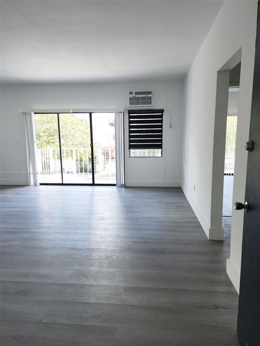 2101 Normandy Drive, Unit 204 Miami Beach, FL 33141 - Photo 8 of 30 wooden floor in an empty room with a window