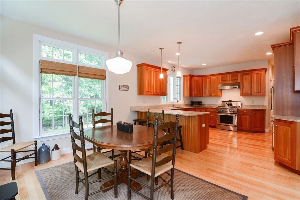 3 Freeman Place Mendon, MA 01756 - Photo 12 of 41 a kitchen with stainless steel appliances granite countertop wooden floor dining table and chairs