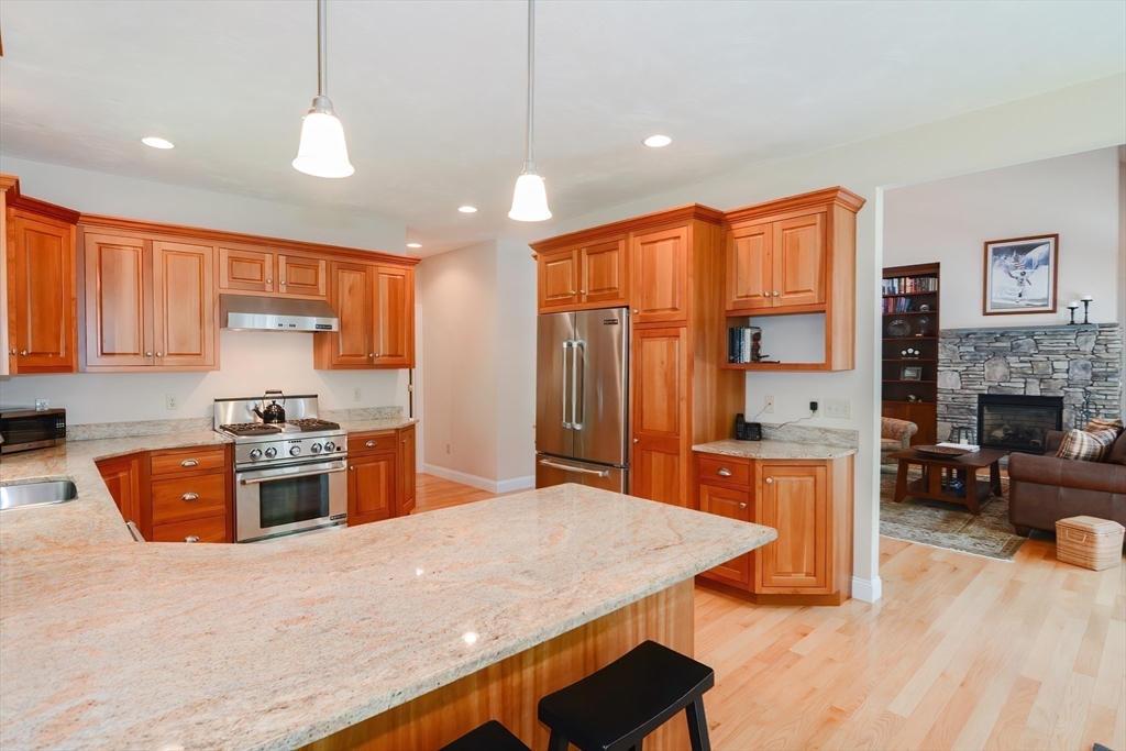 3 Freeman Place Mendon, MA 01756 - Photo 8 of 41 a kitchen with stainless steel appliances granite countertop a stove top oven a sink dishwasher a dining table and chairs with wooden floor