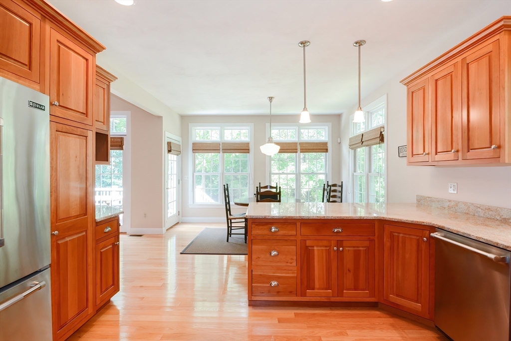 3 Freeman Place Mendon, MA 01756 - Photo 9 of 41 a open kitchen with stainless steel appliances granite countertop a refrigerator a sink dishwasher a dining table and chairs with wooden floor