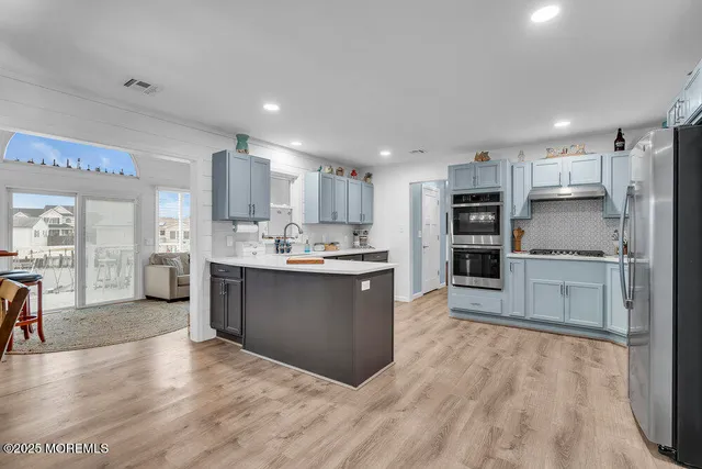 a kitchen with granite countertop a refrigerator and a stove top oven