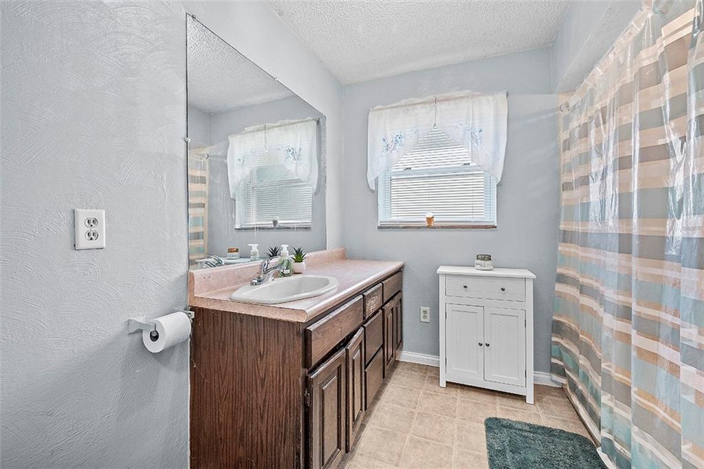 8 Ellen Drive McKees Rocks, PA 15136 - Photo 13 of 25 a bathroom with a double vanity sink a mirror and a bathtub