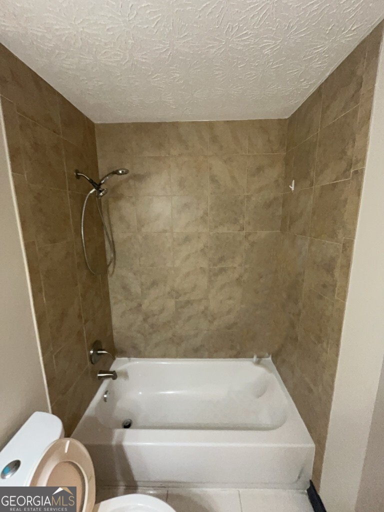 1265 Herrington Road Lawrenceville, GA 30044 - Photo 30 of 52 a bathroom with a tub and a shower