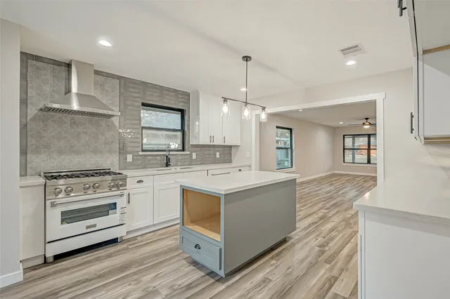 a open kitchen with a sink dishwasher and a stove with wooden floor