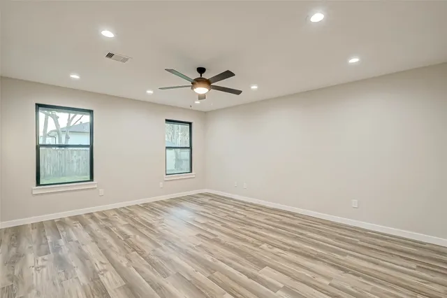 an empty room with a ceiling fan and a window