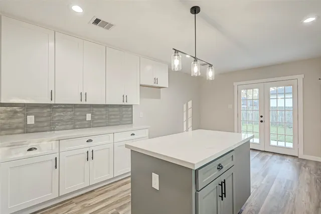 a kitchen with a stove and white cabinets
