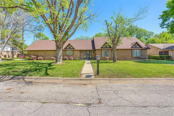 a view of house with garden and tall trees