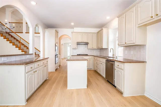 a kitchen with stainless steel appliances granite countertop a stove a microwave and cabinets