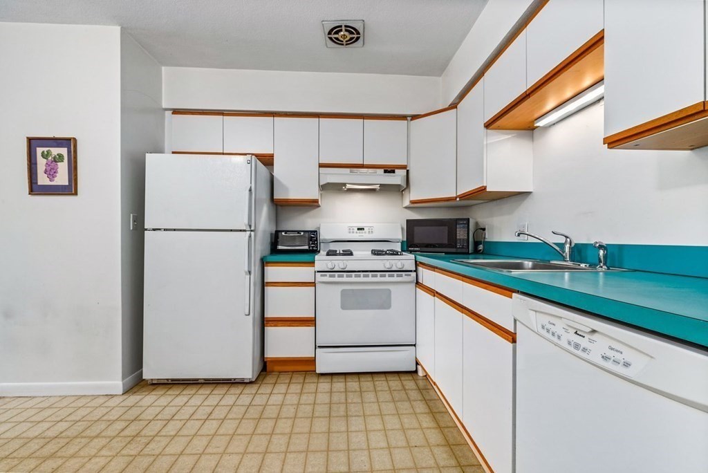 80 Walnut Street, Unit 410 Canton, MA 02021 - Photo 12 of 21 a kitchen with a white stove top oven and cabinets