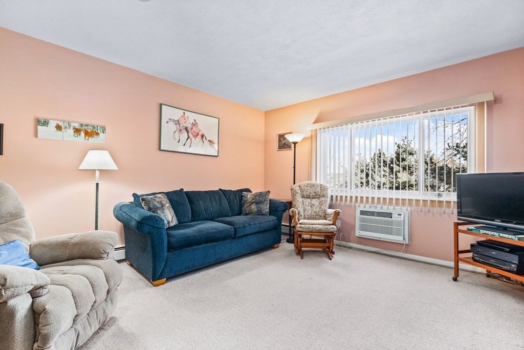 80 Walnut Street, Unit 410 Canton, MA 02021 - Photo 8 of 21 a living room with furniture a flat screen tv and a window