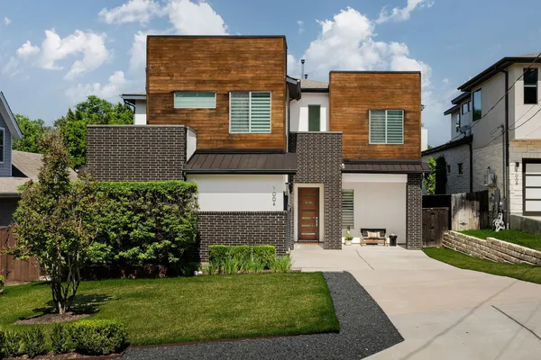 front view of a brick house with a yard
