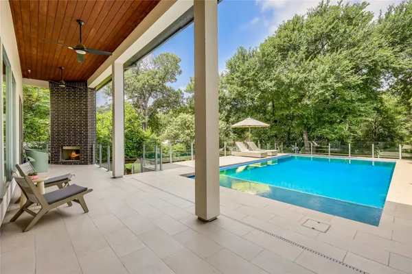 a swimming pool with lawn chairs and pool view