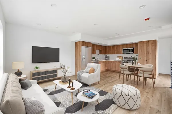 a living room with furniture kitchen view and a flat screen tv