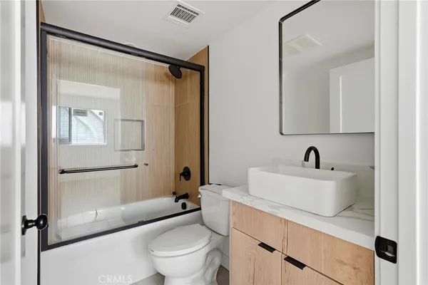 a bathroom with a sink toilet vanity and tub