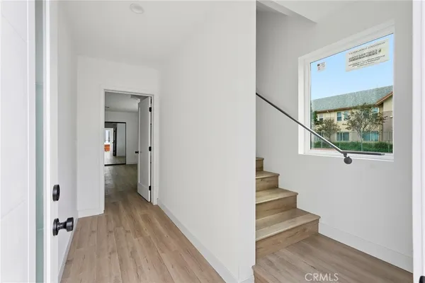 a view of a hallway with wooden floor and staircase