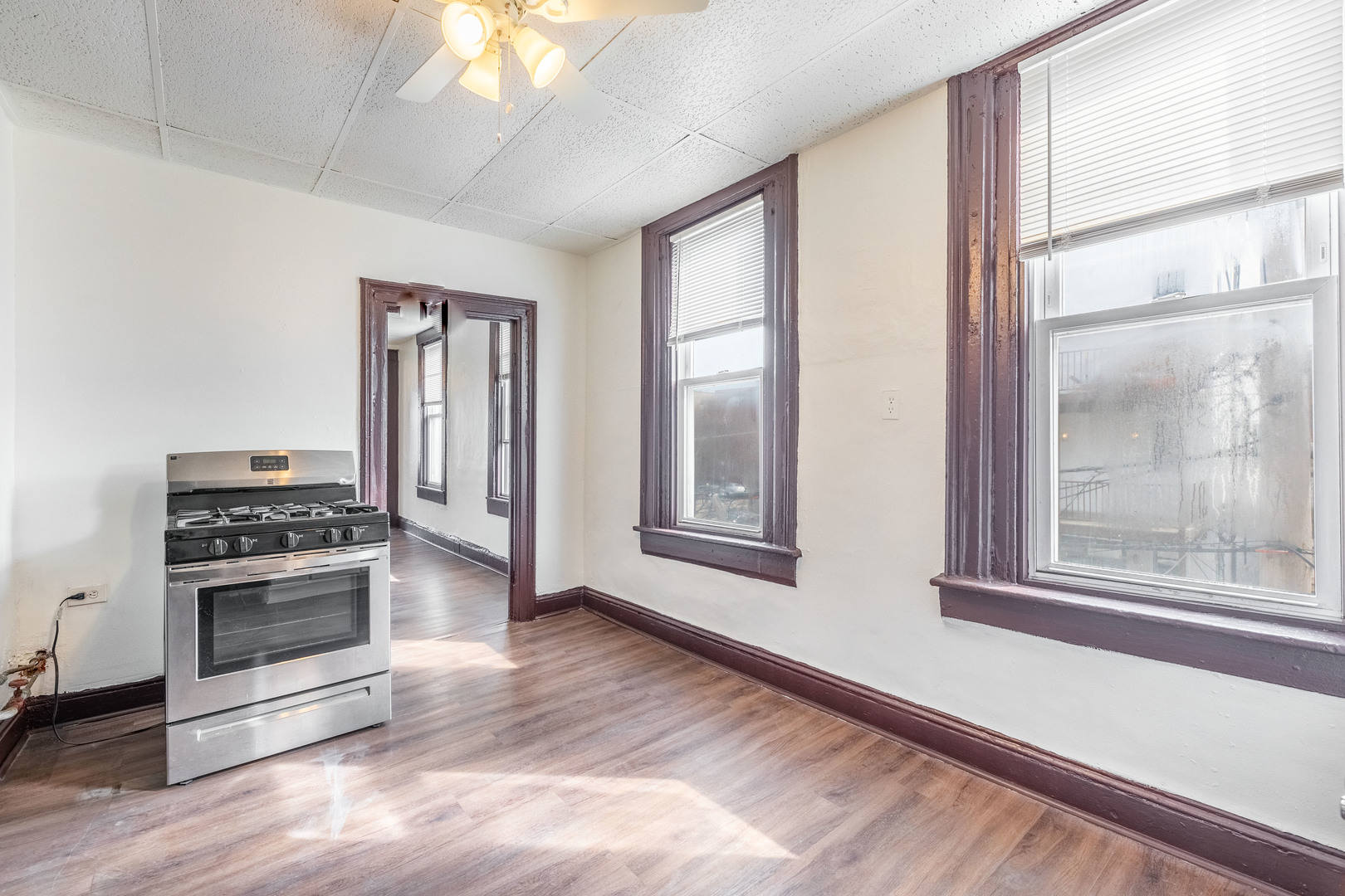1115 West 17th Street, Unit 2F Chicago, IL 60608 - Photo 15 of 28 a view of a kitchen with a stove wooden floor a ceiling fan and windows