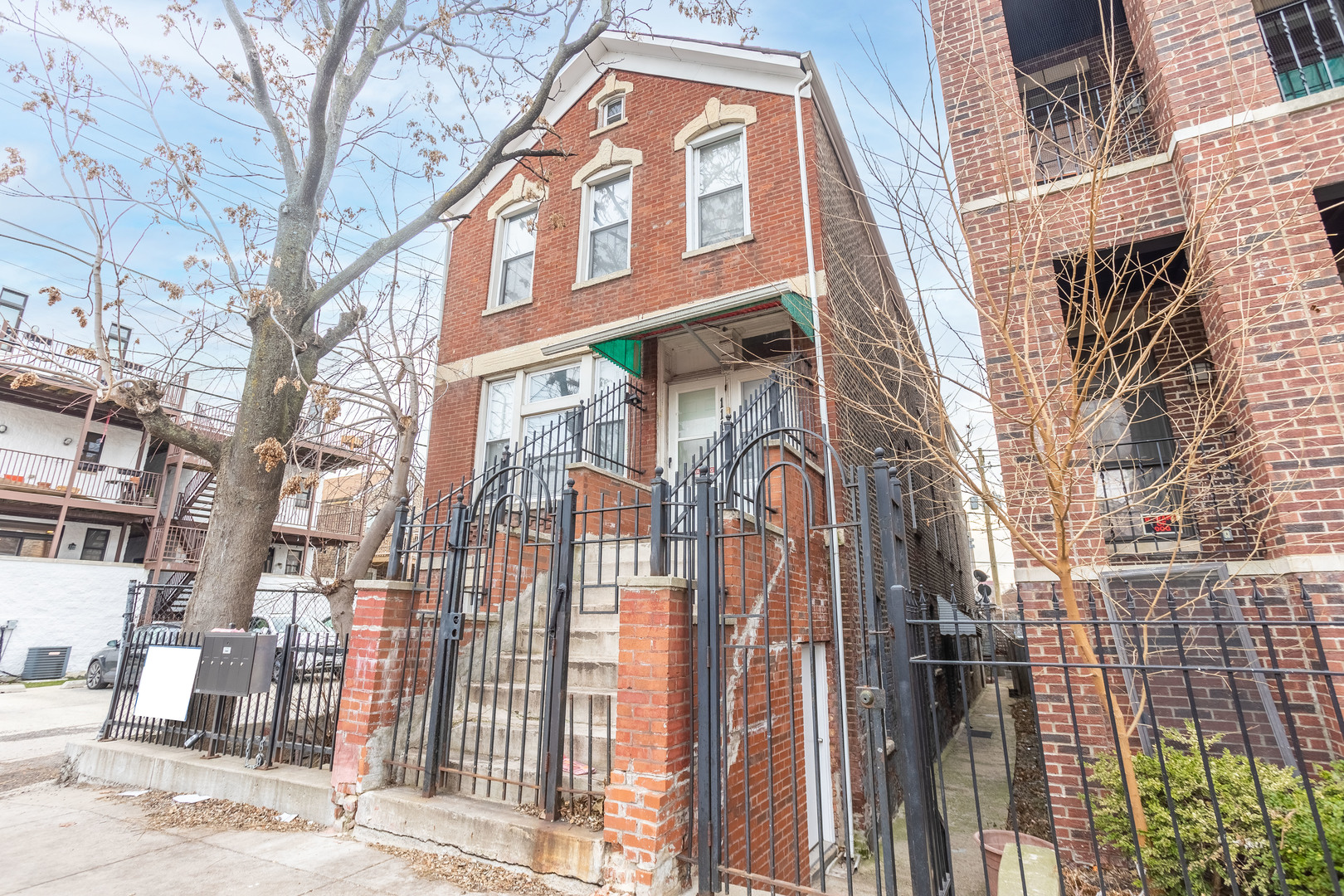 1115 West 17th Street, Unit 2F Chicago, IL 60608 - Photo 3 of 28 a view of a brick building with a tree