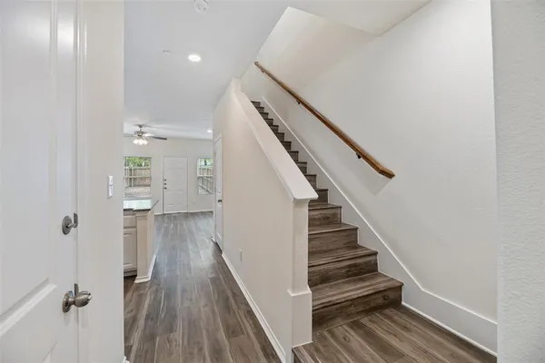 a view of a hallway with wooden floor and staircase