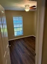 a view of an empty room with a chandelier fan
