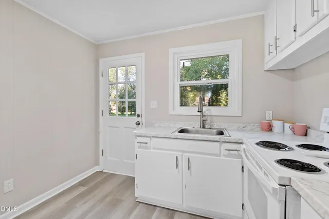 a kitchen with a sink white cabinets and white appliances
