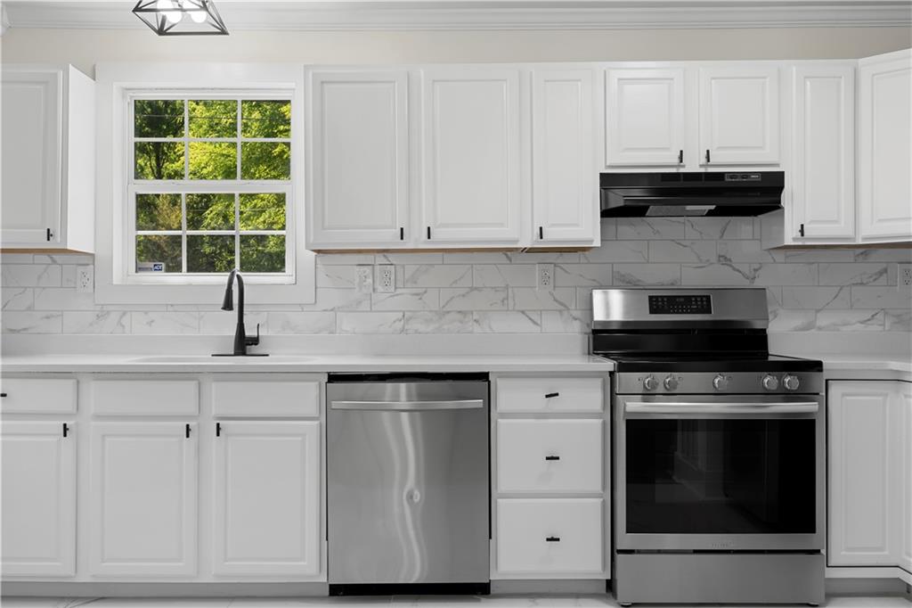 1271 Hayes Street Madison, GA 30650 - Photo 11 of 37 a kitchen with granite countertop white cabinets and a stove