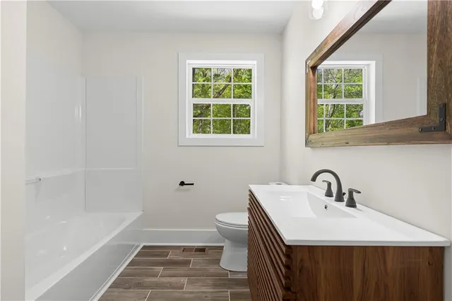a bathroom with a sink toilet and a window