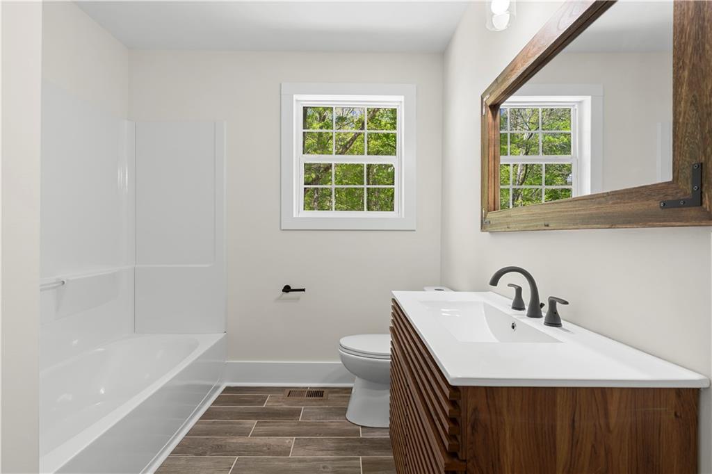 1271 Hayes Street Madison, GA 30650 - Photo 13 of 37 a bathroom with a sink a toilet a tub and a window