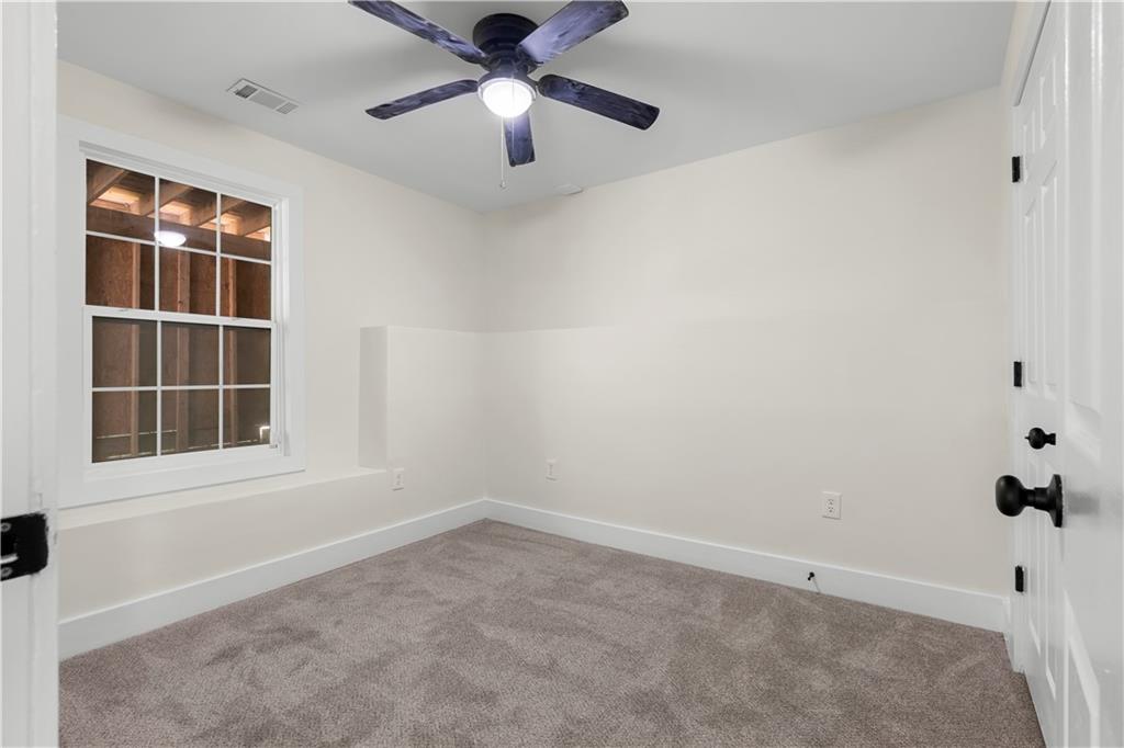 1271 Hayes Street Madison, GA 30650 - Photo 16 of 37 an empty room with windows and ceiling fan