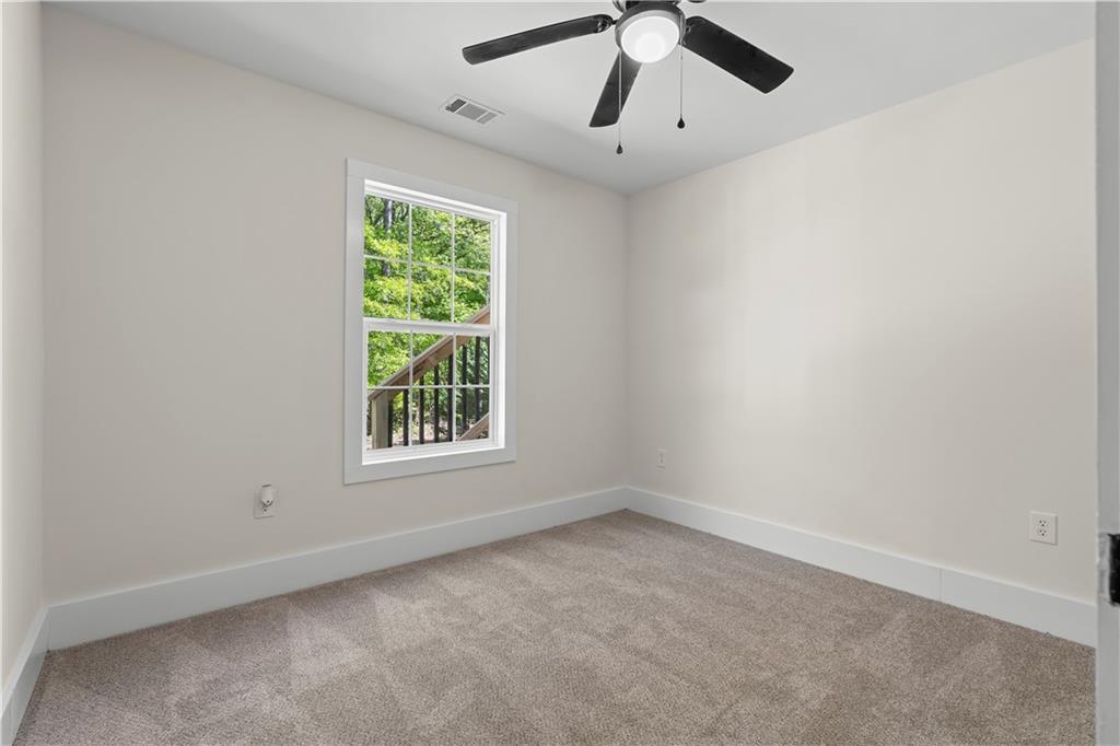 1271 Hayes Street Madison, GA 30650 - Photo 17 of 37 an empty room with a window and a fan