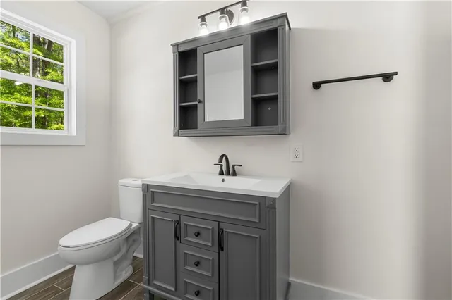 a bathroom with a toilet sink and mirror