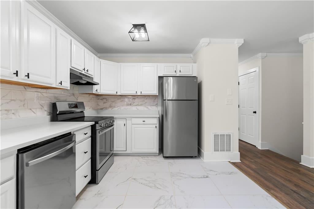 1271 Hayes Street Madison, GA 30650 - Photo 9 of 37 a kitchen with a refrigerator sink and cabinets