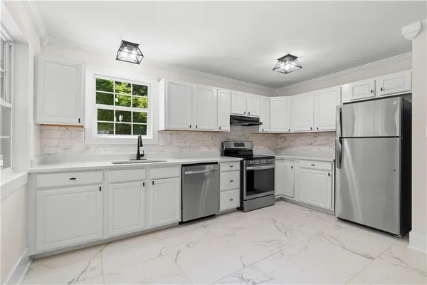 a kitchen with granite countertop white cabinets and a stove