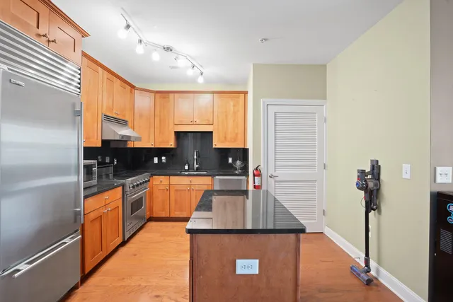 a kitchen with stainless steel appliances granite countertop sink stove and refrigerator