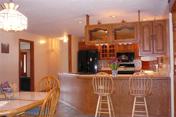 560-570 Mulpus Road Lunenburg, MA 01462 - Photo 9 of 25 a kitchen with stainless steel appliances kitchen island granite countertop a table and chairs