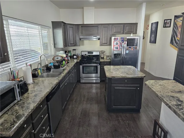 a kitchen with stainless steel appliances granite countertop a stove a sink and a refrigerator