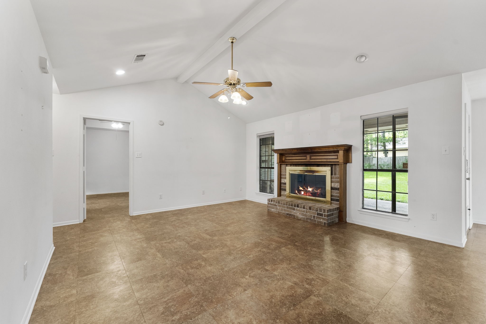 202 Sunset Boulevard Conroe, TX 77303 - Photo 11 of 50 Experience the warmth and spaciousness of this inviting family room, featuring a stunning vaulted ceiling and a cozy fireplace.