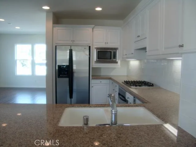 a view of wooden floor fire place and windows in a room