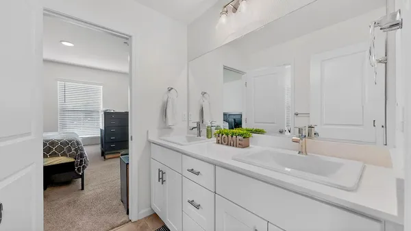a en suite bathroom with double sink and a mirror