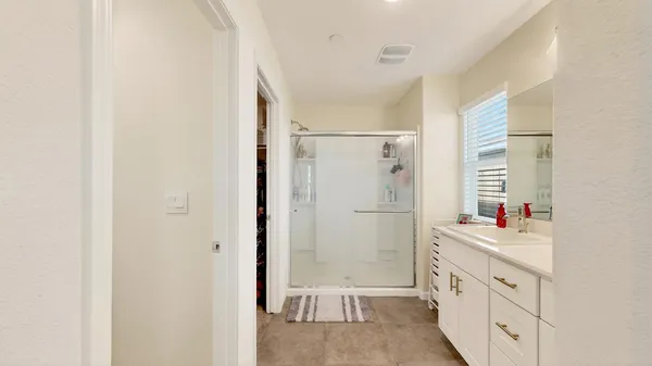 a bathroom with a double vanity sink mirror and shower
