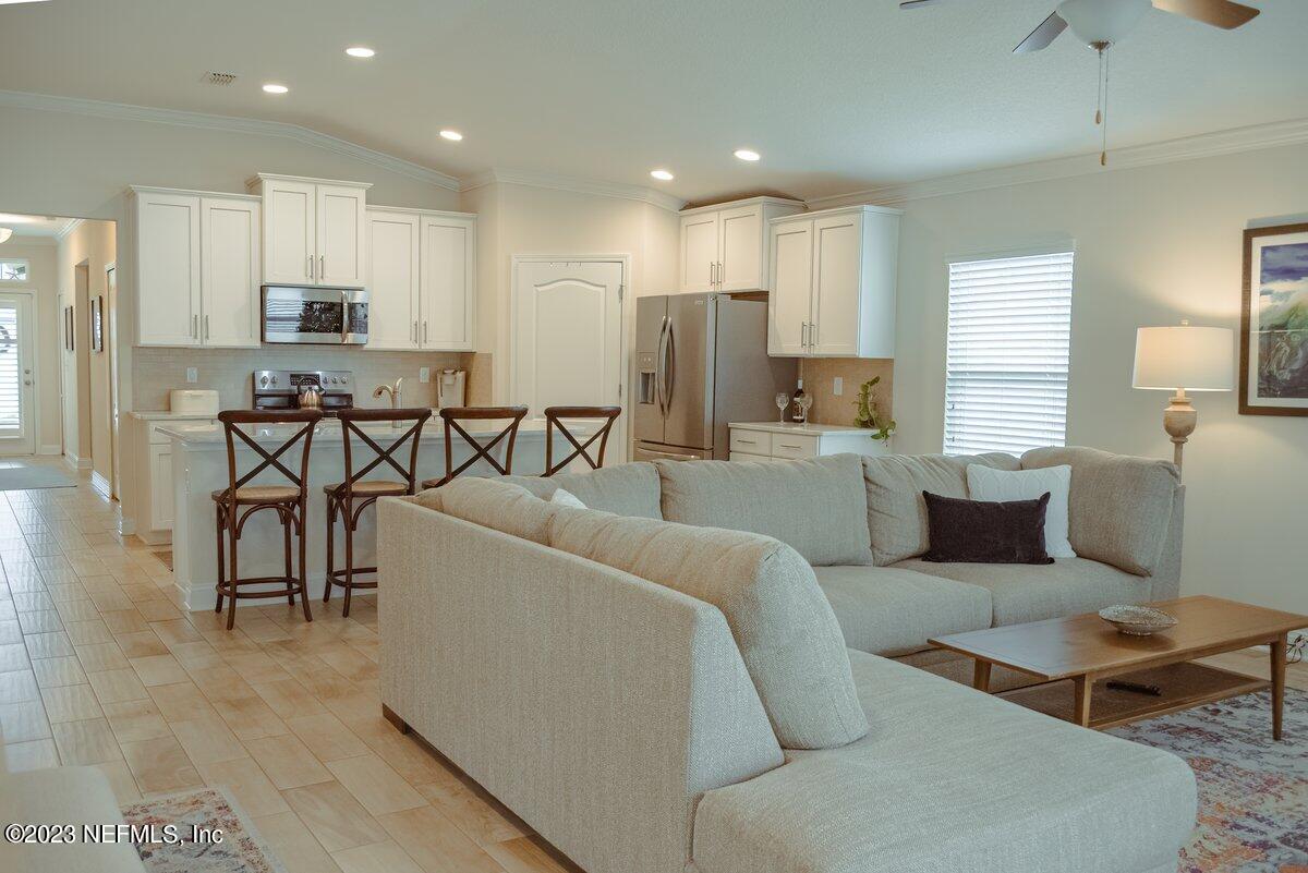 67 Salt Point St. Augustine, FL 32086 - Photo 12 of 39 a living room with furniture a flat screen tv and kitchen view