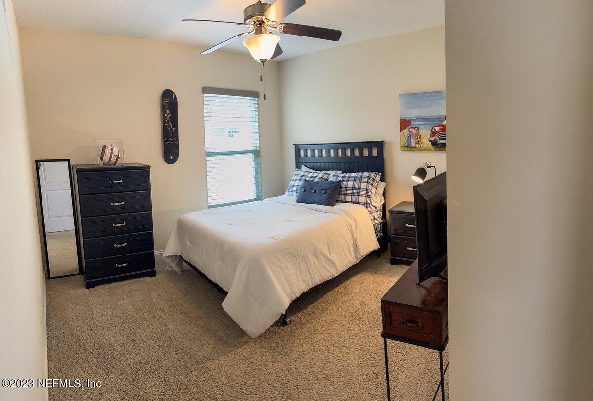 67 Salt Point St. Augustine, FL 32086 - Photo 23 of 39 a bedroom with a bed and a chandelier