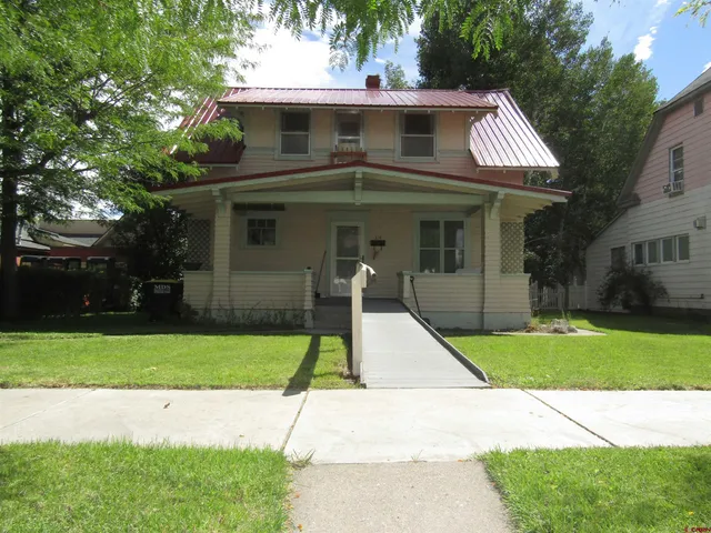 a view of a white house with a yard and plants