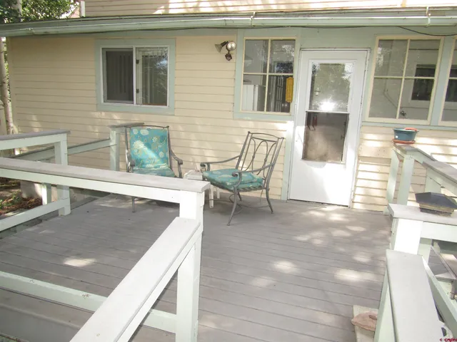 a view of a patio with table and chairs and wooden floor