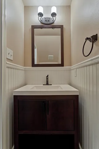 a kitchen with stainless steel appliances kitchen island granite countertop a refrigerator a sink a dining table and chairs with wooden floor